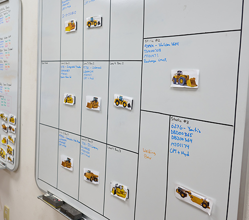 A whiteboard with diagrams of Caterpillar equipment