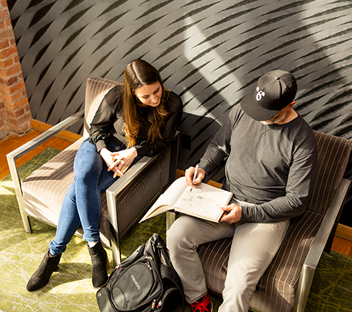 Bird's eye view of two people sitting and looking at a book together