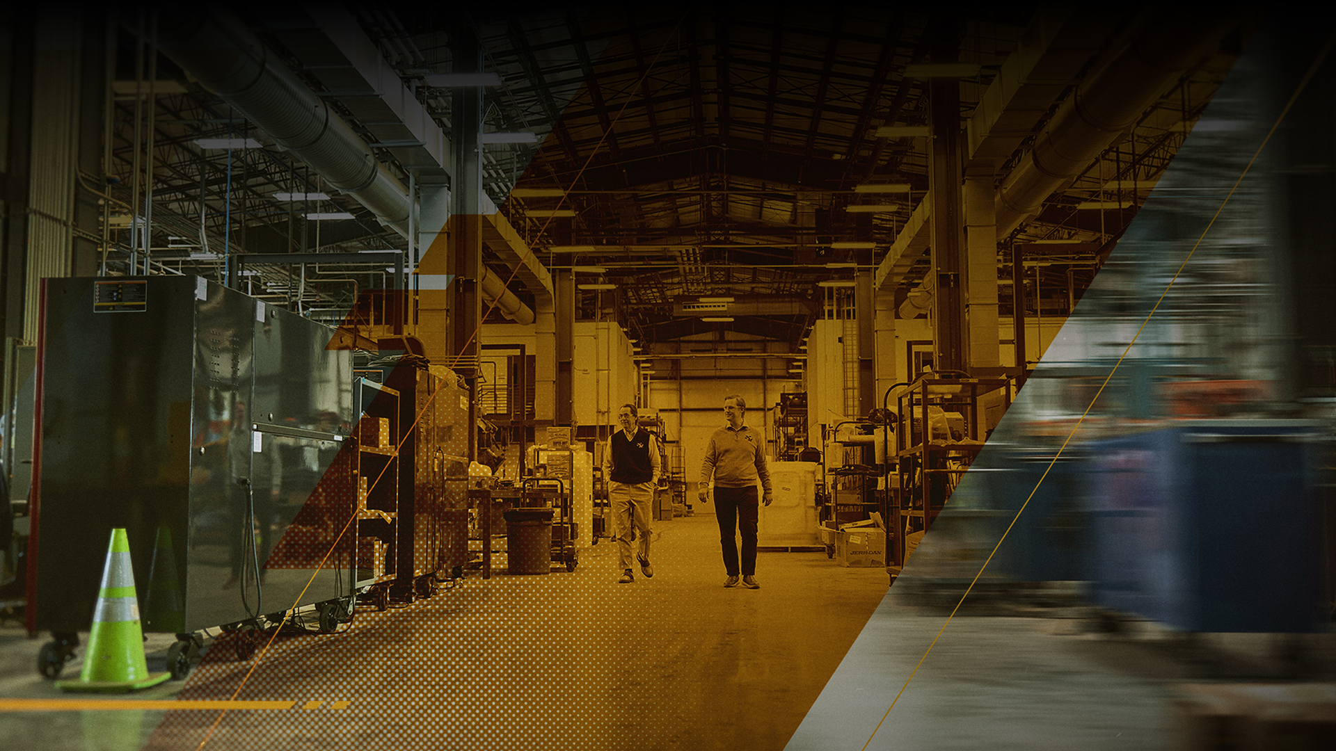 Two people walking through a manufacturing facility.